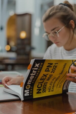 Nursing student studying with notes and textbooks — evidence-based study strategies for passing NCLEX and nursing school exams
